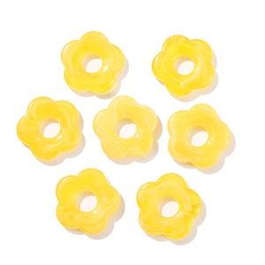 Macro detail of seven yellow acrylic flower beads with marble texture and center holes