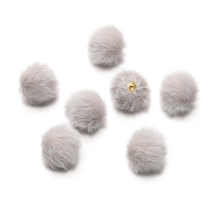 Macro shot of 17mm light grey plush faux mink fur pompoms with gold metal hanging loops