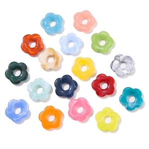 Flat lay of 26mm acrylic flower beads in various marbled colors for DIY jewelry making