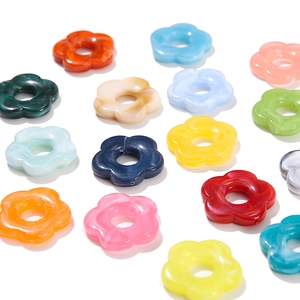 Flat lay view of colorful five-petal acrylic flower beads with central holes for DIY
