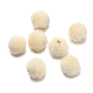 Close-up of soft ivory faux mink fur ball charms with golden metal loops for DIY jewelry