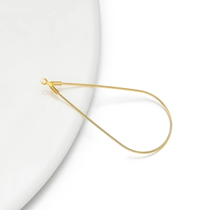 Macro-opname van gouden druppeloorbelbedels met oogje voor DIY-sieraden maken