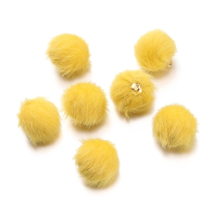 Macro detail of yellow faux mink fur pompom beads with golden metal loops for DIY crafts