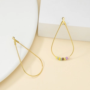 Detail van gouden druppelvormige bedeltjes met kleurrijke kralen voor DIY sieraden