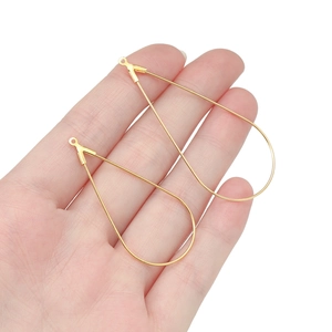 Gouden druppelvormige bedeltjes voor DIY-sieraden maken op een witte achtergrond