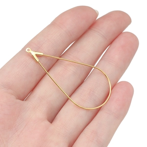 Detailopname van een grote gouden traanhanger in de hand voor DIY-sieraden maken van metaal