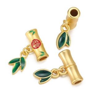 Detail of matte gold bamboo-shaped pendants with green enamel leaves and 福 character
