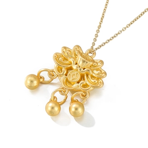 Macro detail of golden lotus Ruyi pendant with ancient coin pattern and metal beads