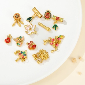 Detailed close-up of golden enamel charms including bamboo, koi fish, and lucky bag designs