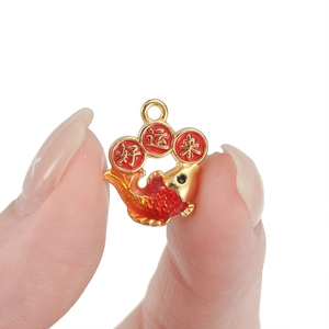 Macro shot of koi carp pendant in red enamel and gold finish with good luck inscription
