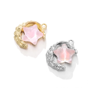 Detailed view of moon and star charms with pink stone inlay for DIY jewelry making