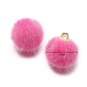 Macro-opname van 15mm roze kunstbont pompons met goudkleurige metalen ophanglussen