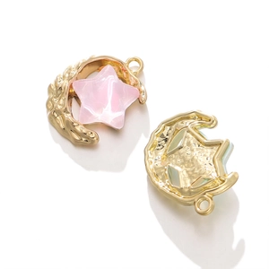 Detail of moon and star pendant charm with gold plating and pink resin star inlay