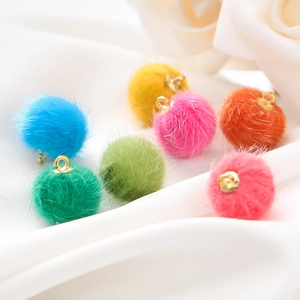 Macro-opname van 15mm imitatiebont pompons in kleuren met gouden metalen lussen voor DIY