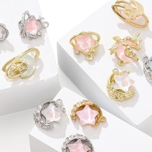 Detailed view of star and moon charms with iridescent resin inlay for DIY jewelry