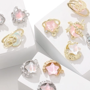Detailed view of moon and star alloy charms with inlaid rhinestones and pearl finish