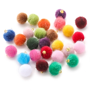 Macro detail van kleurrijke 15mm imitatiebont pompons met gouden metalen lussen voor DIY
