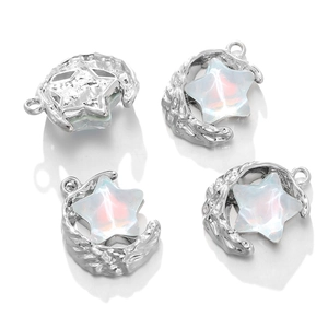 Detailed view of moon and star charms with opal-like resin and silver-plated finish