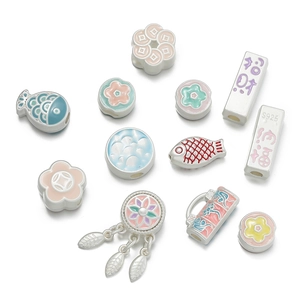 Detailed macro of S925 silver koi and flower charms with colorful enamel finish