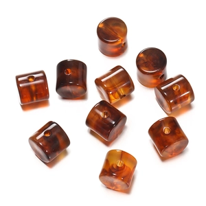 Detailed view of amber tortoise shell acrylic cylinder beads with marble texture for DIY