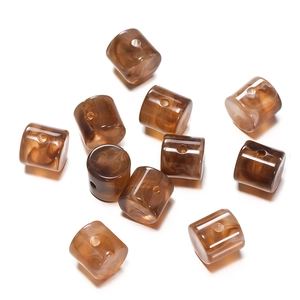 Macro view of cylindrical acrylic beads with brown marble texture and center holes