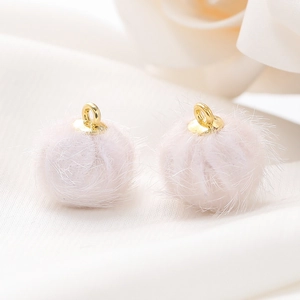 Close-up van zachtroze 15mm imitatiebont pompon bedeltjes met gouden lussen voor sieraden