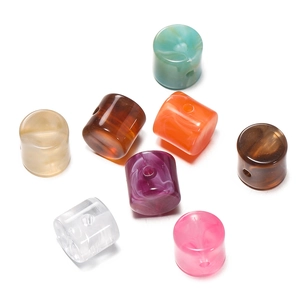 Flat lay of textured acrylic cylindrical beads with marble patterns for DIY jewelry