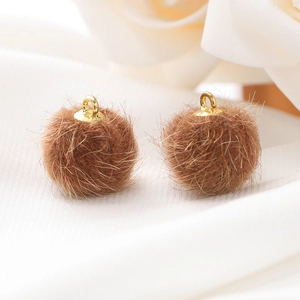Close-up van bruine imitatiebontballen met gouden metalen lussen voor DIY-sieraden
