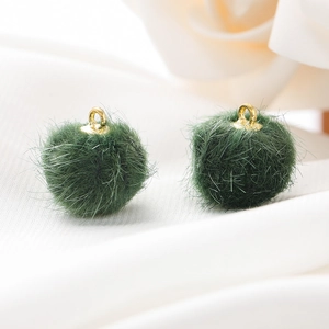 Detail van smaragdgroene 15mm imitatiebont pompons met gouden metalen ophanglussen