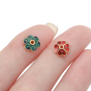Macro shot of 10mm flower enamel spacers in red and green for DIY jewelry making