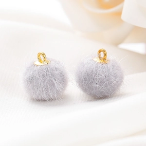 Detailopname van 15mm imitatiebont pompons met gouden metalen lussen voor DIY-sieraden