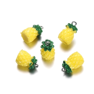 Macro shot of five yellow resin pineapple charms with green leaves and metal rings