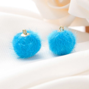 Detailopname van helderblauwe imitatiebont pompons met gouden ringen voor DIY-sieraden maken