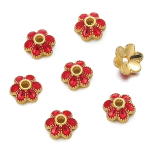 Macro shot of 10mm flower-shaped gold-plated spacer beads with red enamel inlay details