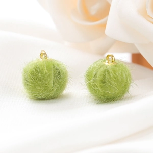 Macro-opname van een groene faux bont pompon met gouden metalen ring voor DIY-accessoires