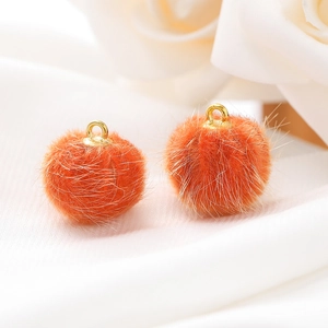 Detail van 15mm oranje faux bontballen met gouden metalen lussen voor DIY-sieraden