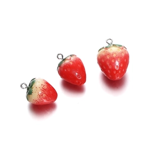 Detailed view of three resin strawberry charms with silver rings for DIY jewelry