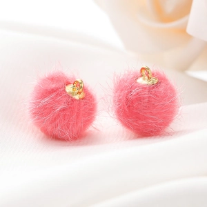 Macro-detail van zachte roze faux nertsbont ballen met gouden metalen ophanglussen