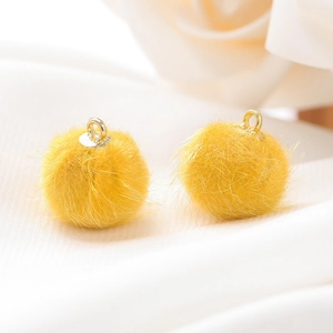 Macro-opname van 15mm felgele faux nertsbont pompon hangers met metalen ophanglussen