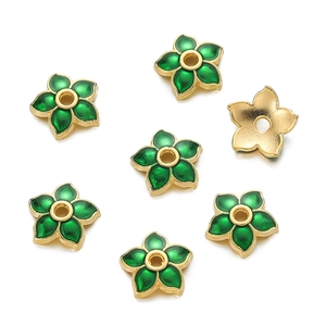 Macro detail of 10mm flower bead caps in 18K gold and green enamel for DIY jewelry making