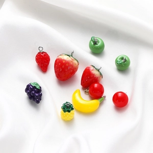 Detailed close-up of colorful resin fruit pendants with silver metal hooks for DIY crafts