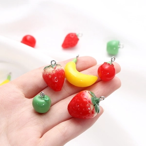 Detailed macro shot of realistic resin fruit charms with metal hooks for DIY jewelry