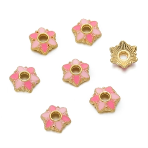 Detailed macro view of 10mm flower-shaped pink enamel spacer beads with 18K gold edges