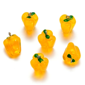 Macro detail of six yellow resin bell pepper pendants with silver hooks for DIY jewelry