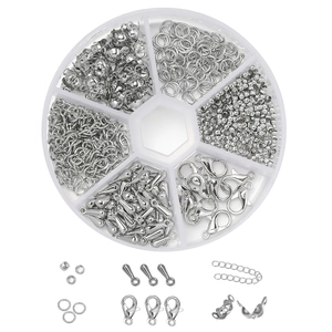 Detalle de accesorios de joyería de plata con cierres y anillos en una caja de 6 compartimentos