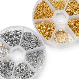 Detalle de kit de joyería DIY con cierres de langosta y anillos en caja organizadora