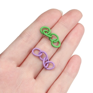 Macro detail of matte painted 4-link chain connectors in green and purple for DIY jewelry