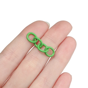 Close-up of green painted four-link metal chain connector for DIY jewelry making