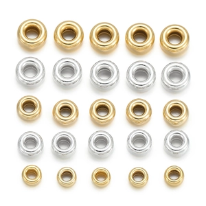 Flat lay of polished silver and gold spacer beads in three sizes for DIY jewelry