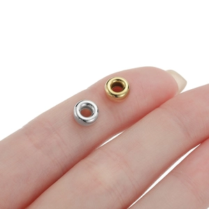 Macro shot of 925 silver and gold spacer beads for DIY jewelry making on fingertip
